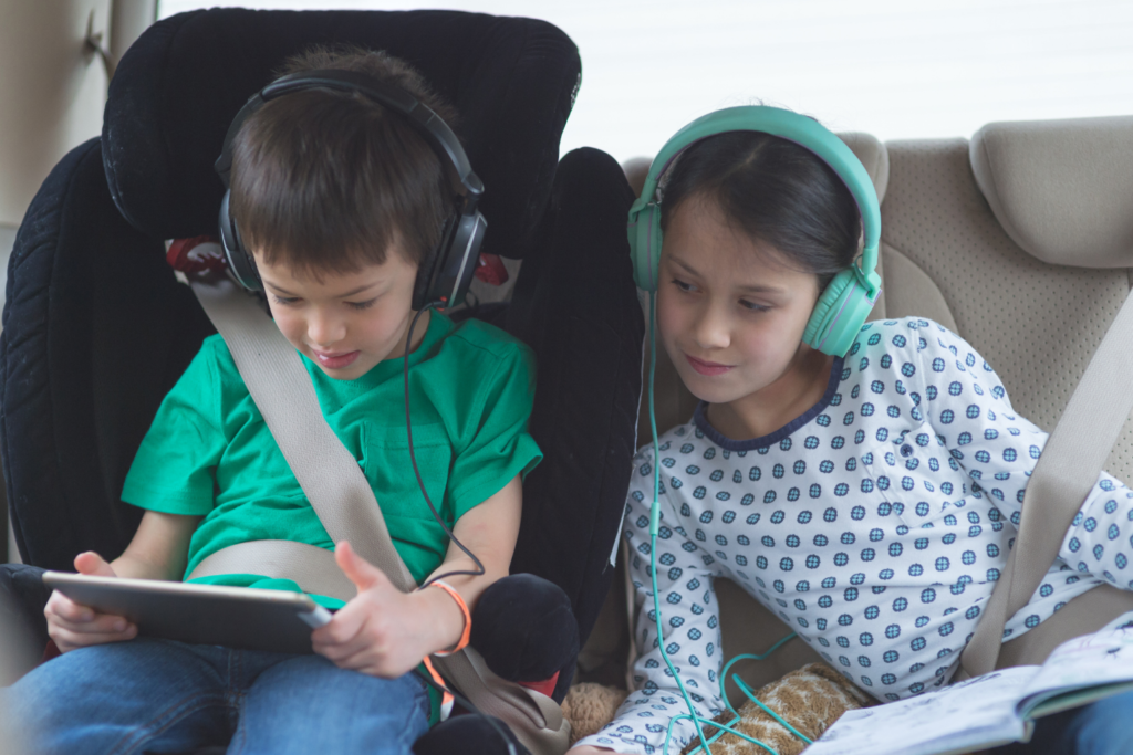 kids playing on ipad in the backseat of a car for the manzanilla sophia blog