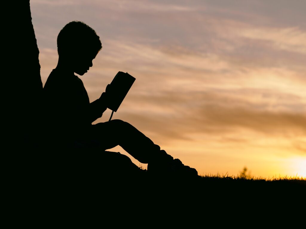 child reading book by sunset for the manzanilla sophia blog