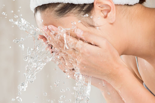 woman washing her face for the manzanilla sophia blog