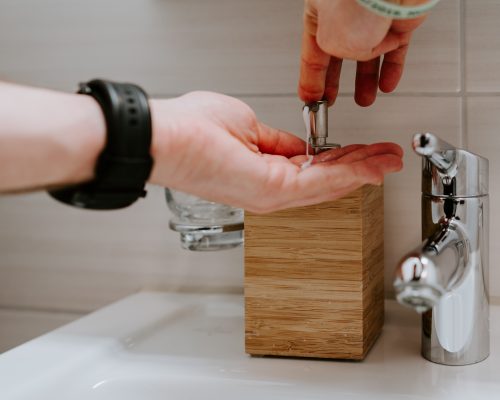 person washing hands at sink for the manzanilla sophia blog